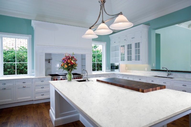 A Carrara marble worktop in a white and green kitchen
