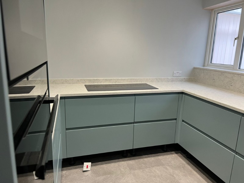 Green kitchen with white worktop