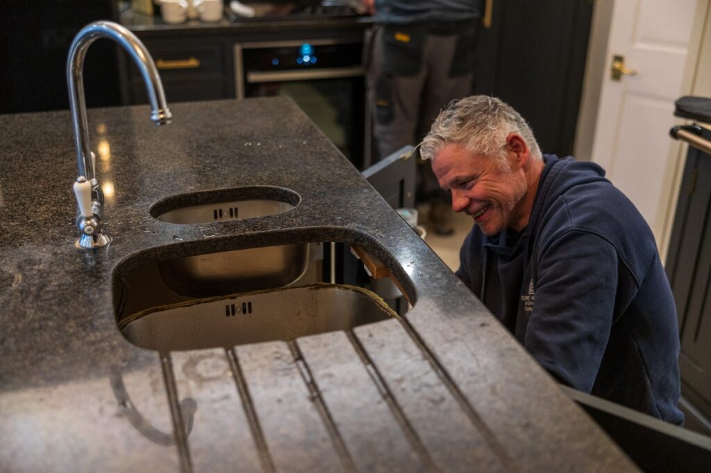 The SMG team removing an old dark granite worktop